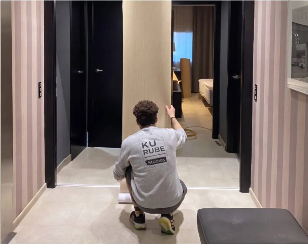 Instalador de Kurube Studio revistiendo una puerta en un pasillo de hotel