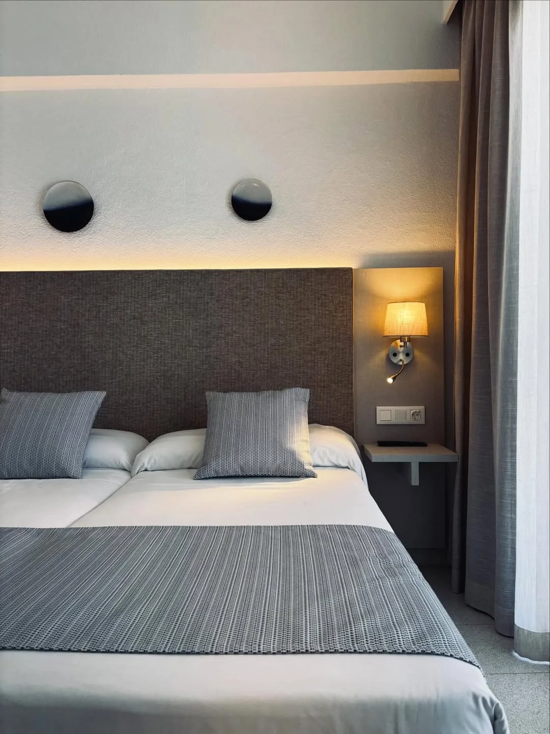 Habitación de hotel con cabecero revestido en vinilo textil